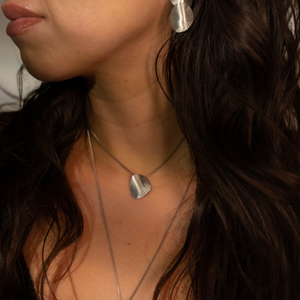 Close-up of a woman wearing silver jewelry with a blurred background