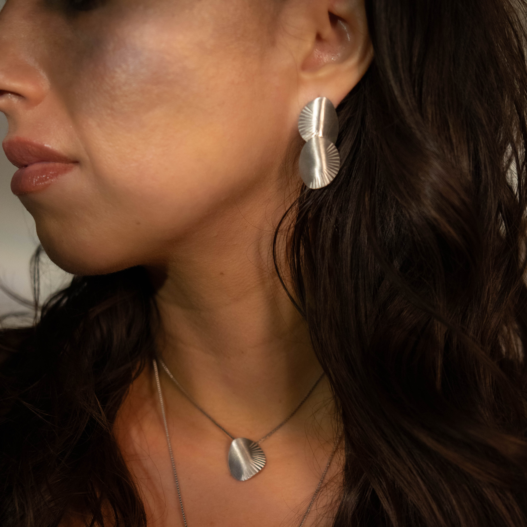 Close-up of a woman wearing silver jewelry with a blurred background