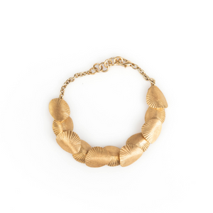Gold necklace with leaf-like design on a white background