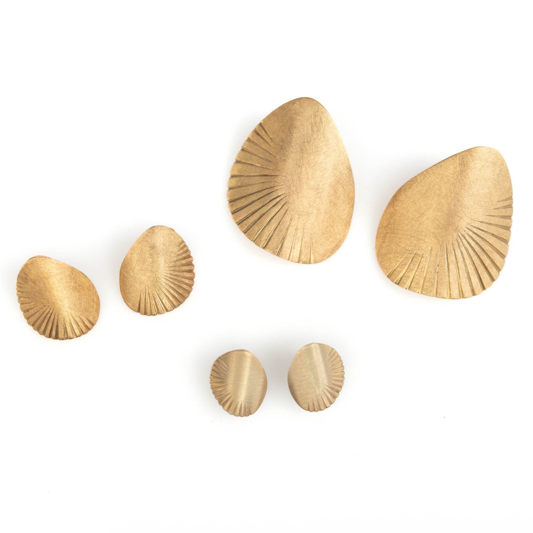 Set of gold shell-shaped wall hooks on a white background